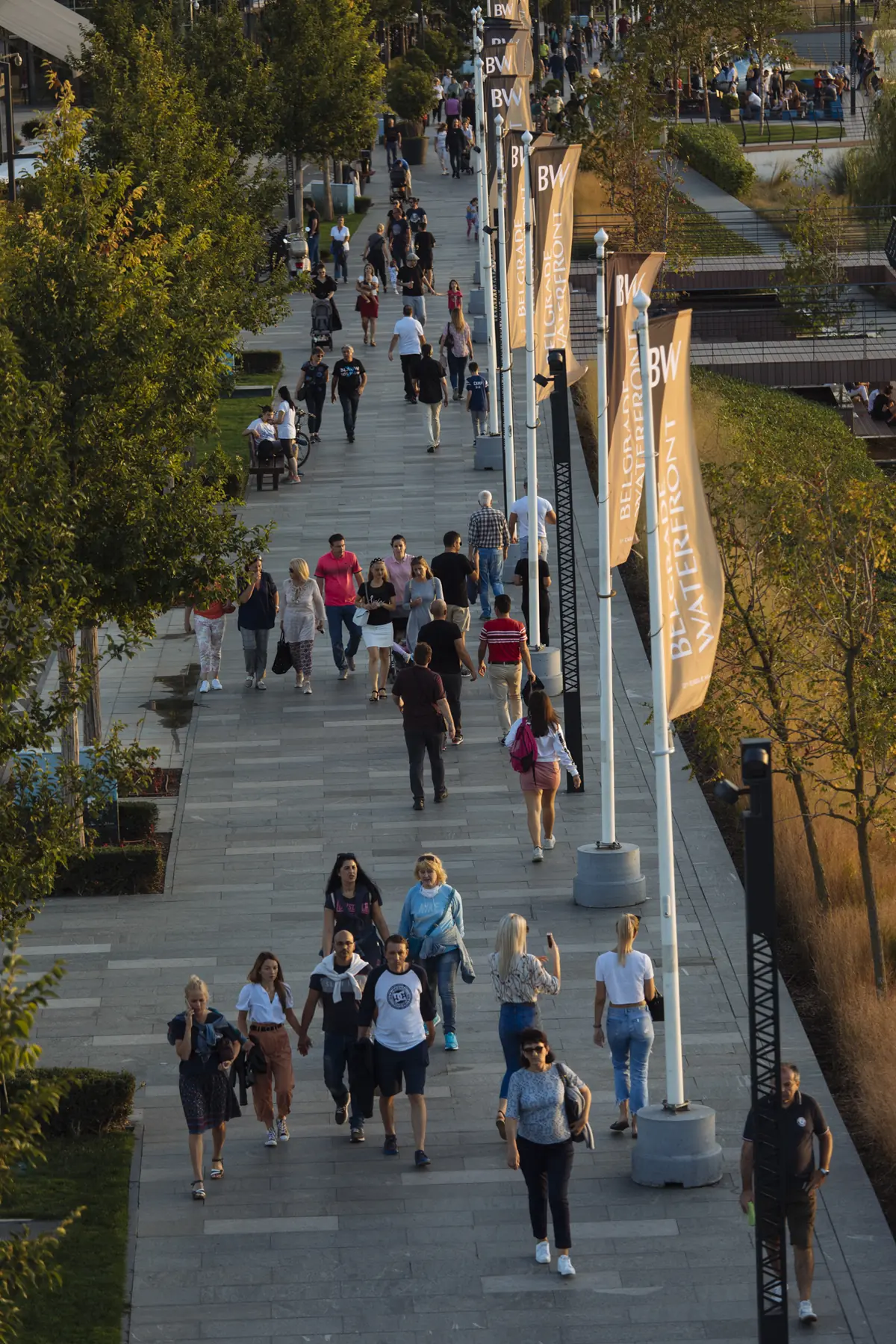 The riverside promenade from above, crowded with people at golden hour